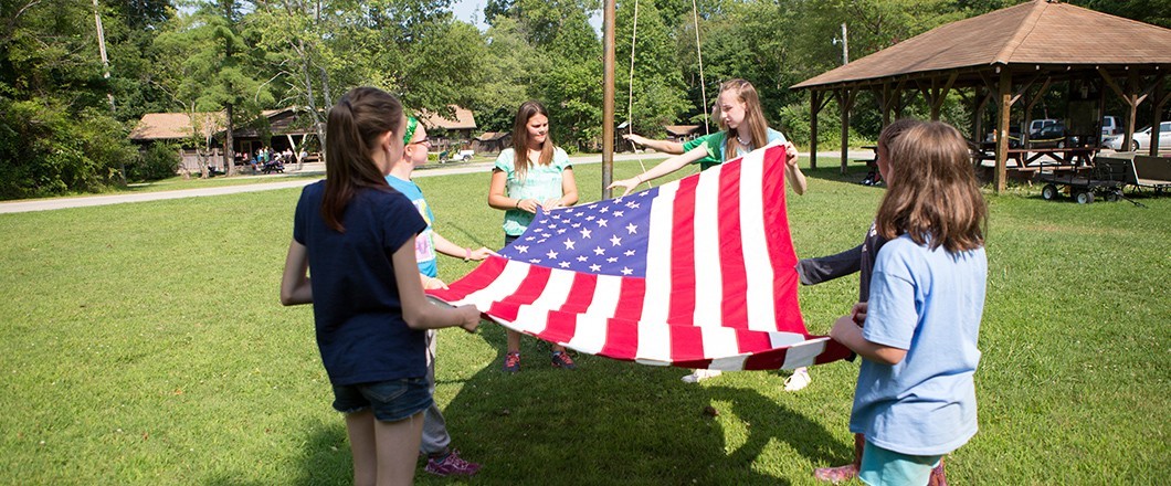 A group of Girl Scouts conduct a Flag Ceremony at camp Flag ceremonies are just one of many Girl Scout traditions