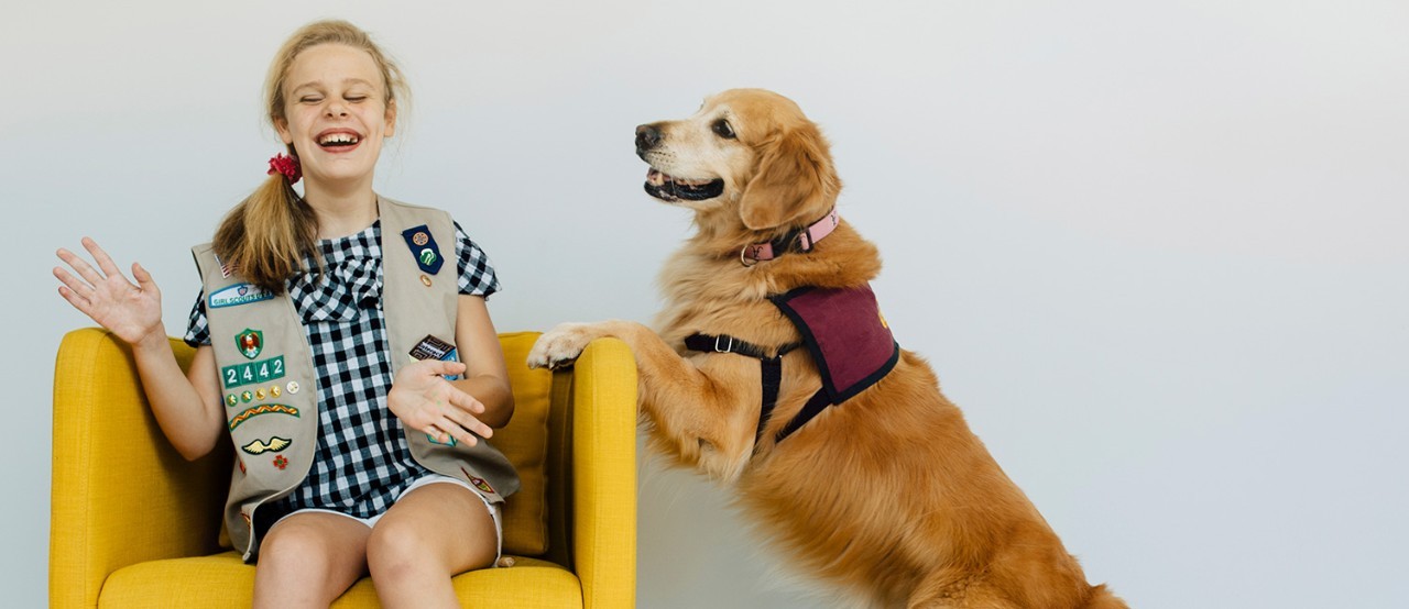 Girl Scout Cadette playing with a golden retriever Girl Scout Cadette playing with a golden retriever