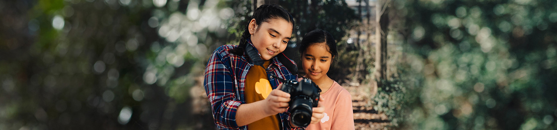  two young girl scouts outside with professional photo camera nature photography 