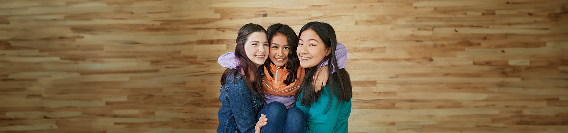  Two Cadette Girl Scouts holding a third in their arms 