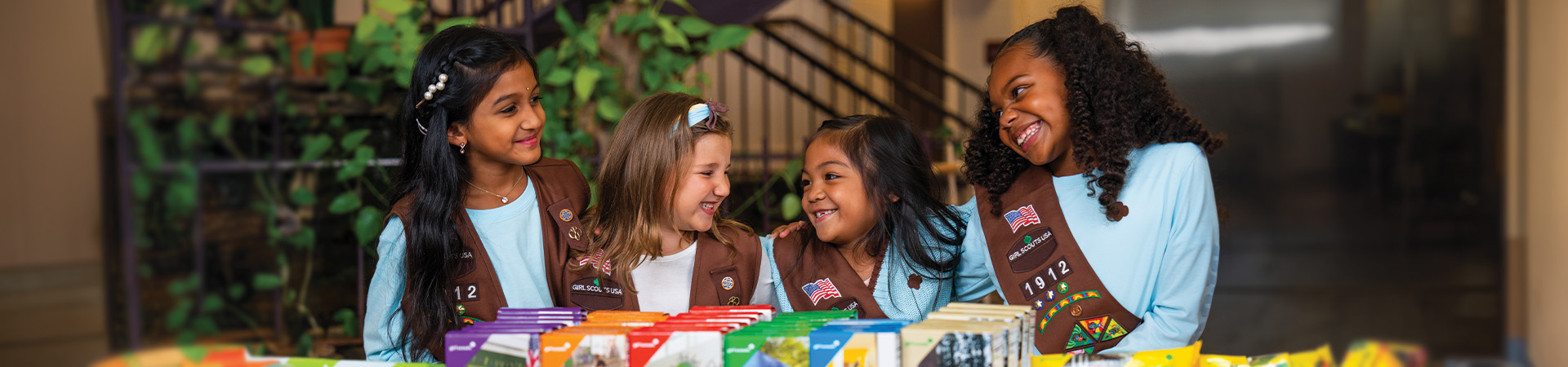  tres Girl Scout Brownies en un puesto de galletas 